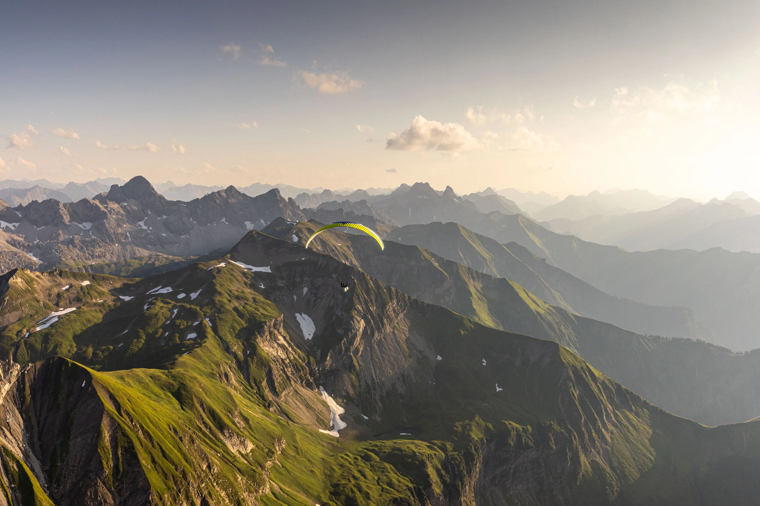 Skitourengeher beim Aufstieg in den verschneiten Allgäuer Alpen bei goldenem Morgenlicht